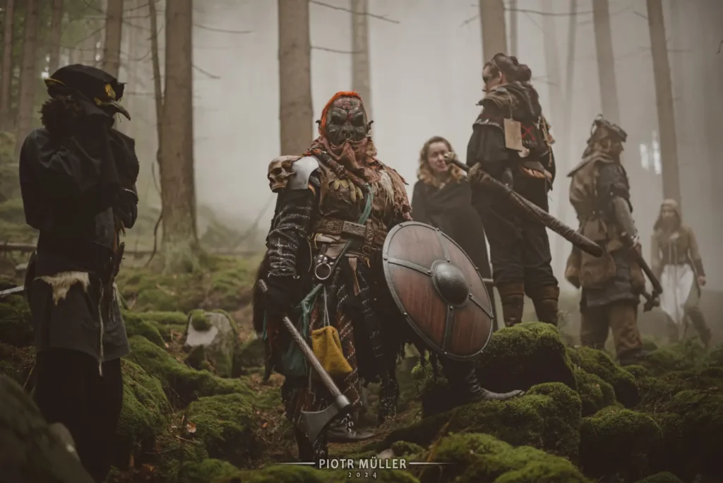 Ork w kostiumie fantasy z tarczą i toporem na planie filmu LARP