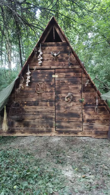 Front drewnianej chatki zielarki w lesie z detalami i zawieszkami
